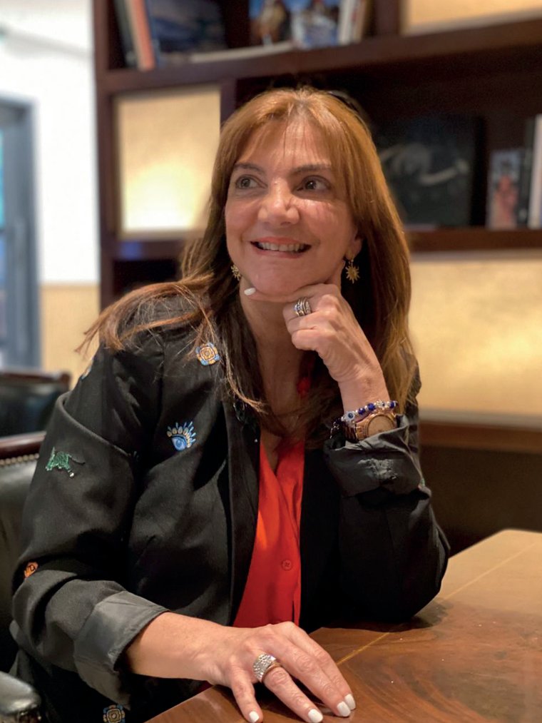 Andrea Israel en su estudio, apoyada sobre el escritorio